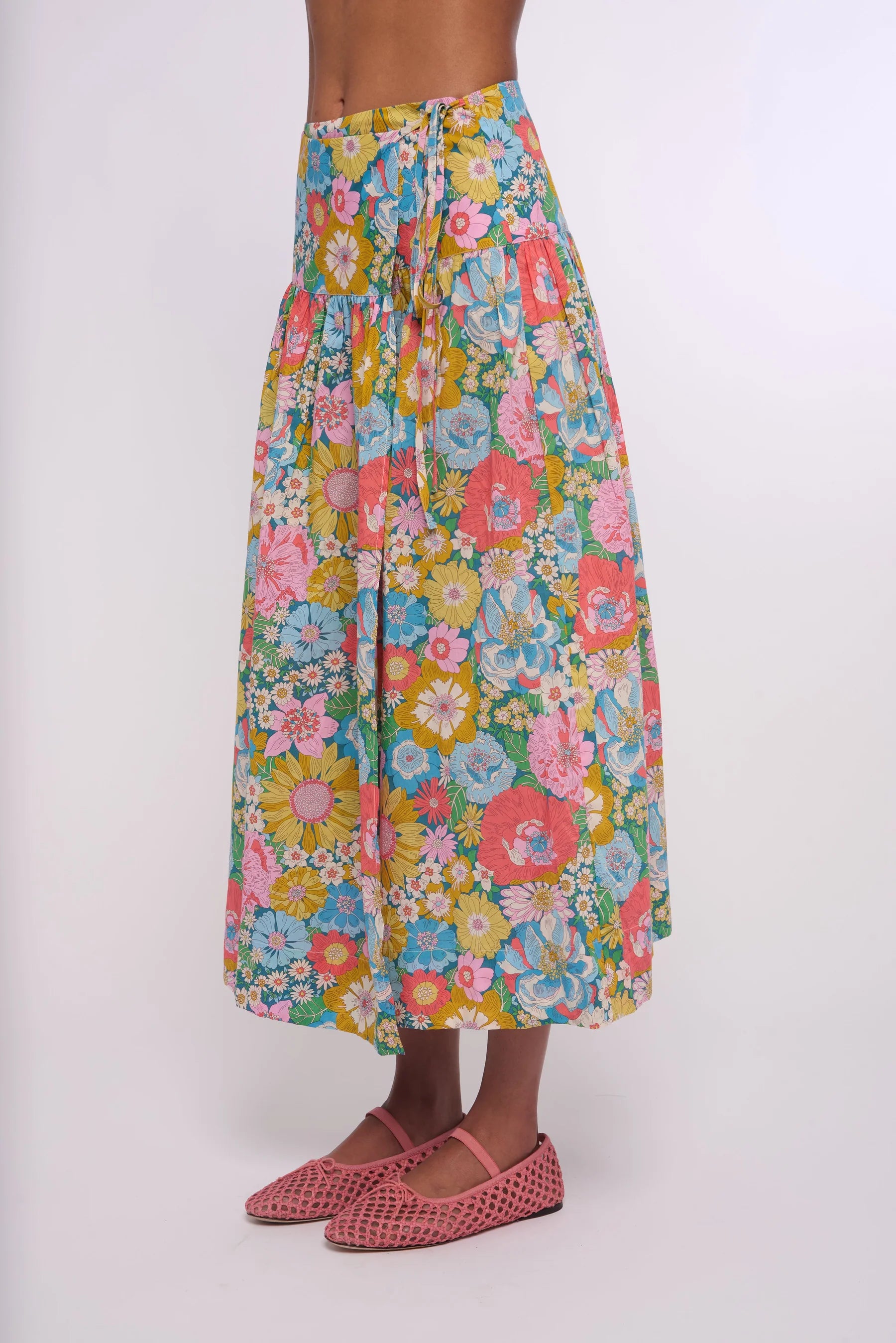 Multicolored floral skirt worn by a person on a white background