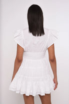 Woman wearing a white dress with a plain background