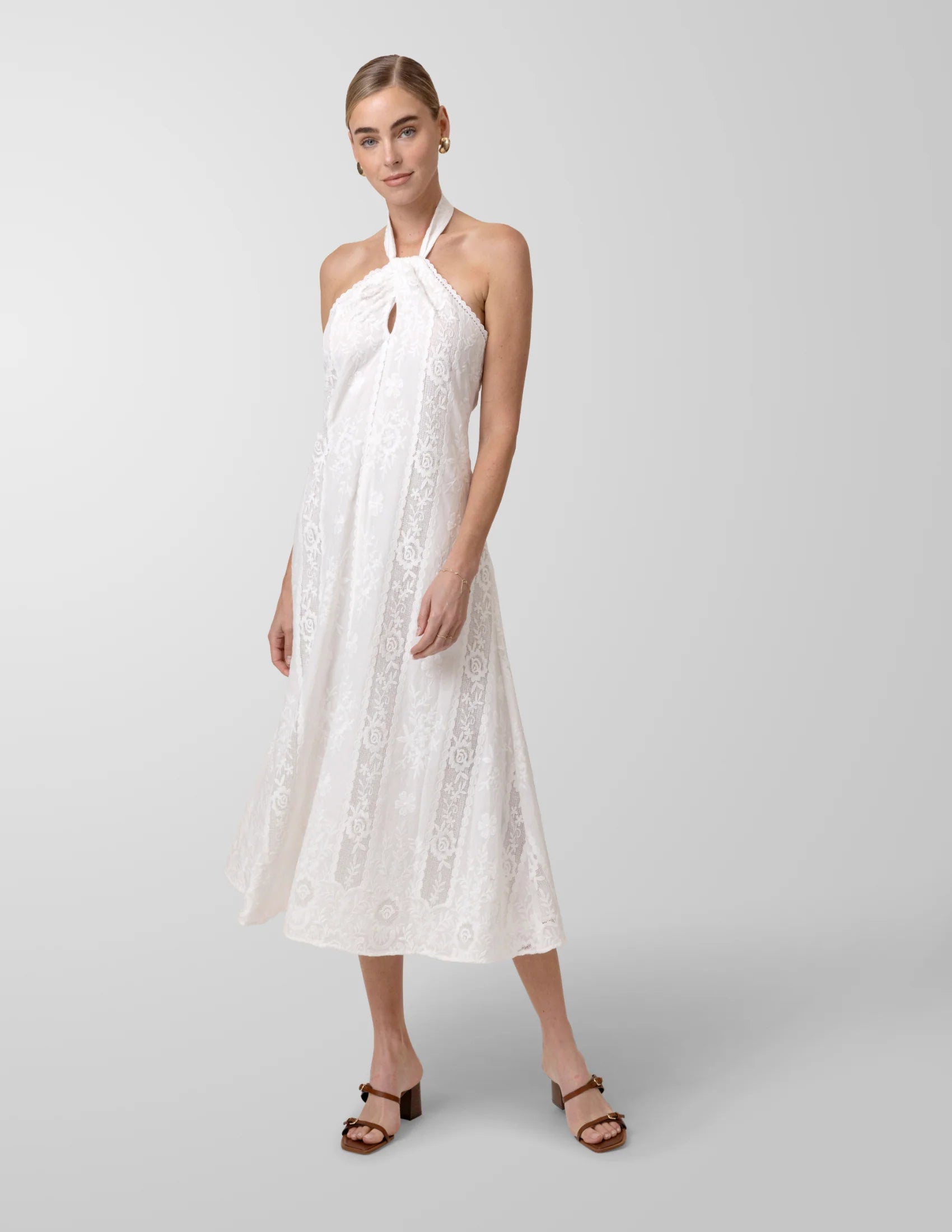 Woman wearing a white lace dress on a gray background