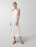 Woman wearing a white lace dress on a gray background
