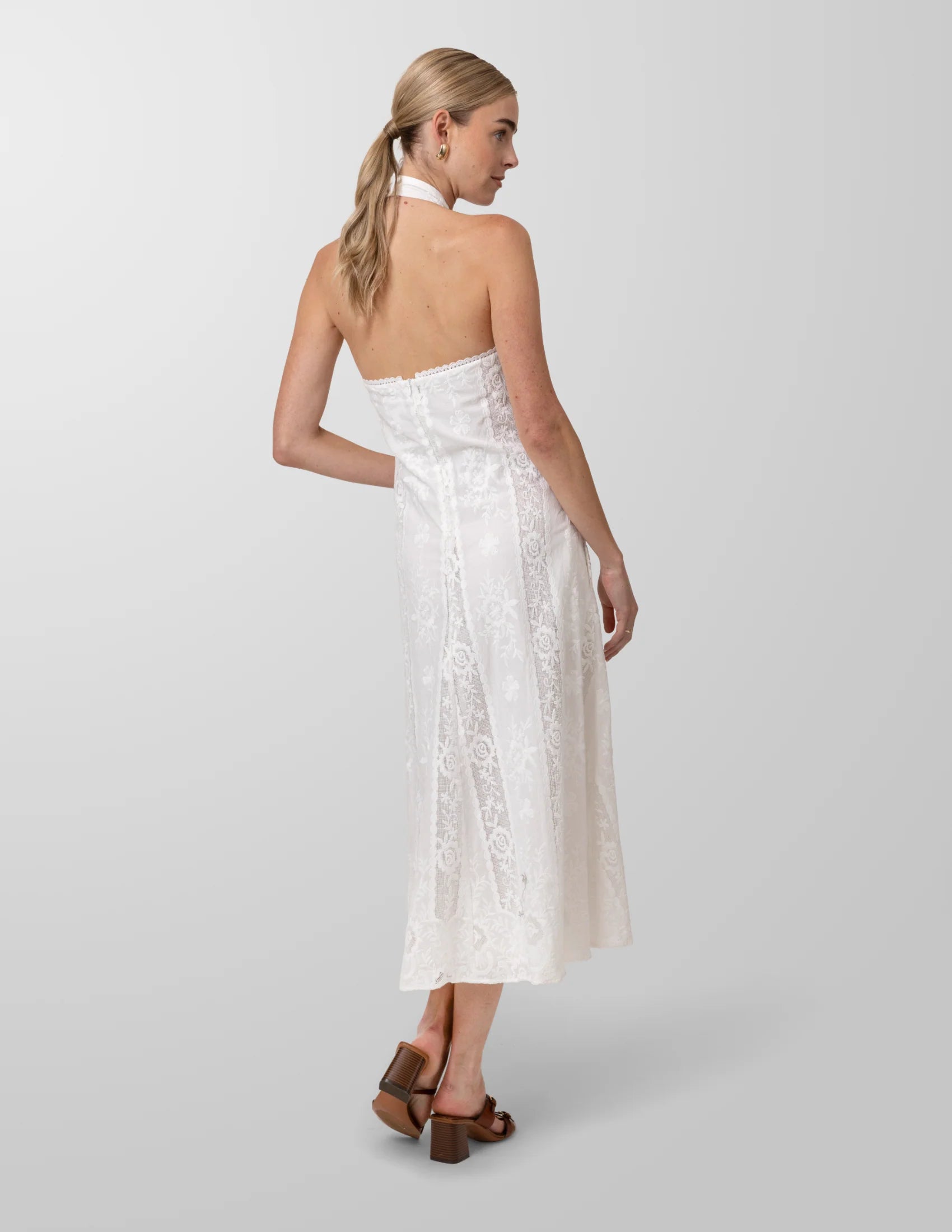 Woman wearing a white strapless dress on a plain background