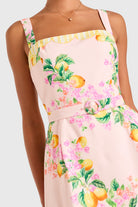 Pink dress with floral and fruit pattern on a white background