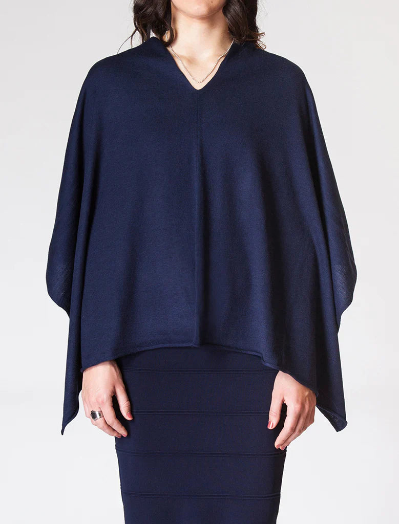 Navy blue poncho worn by a person on a white background