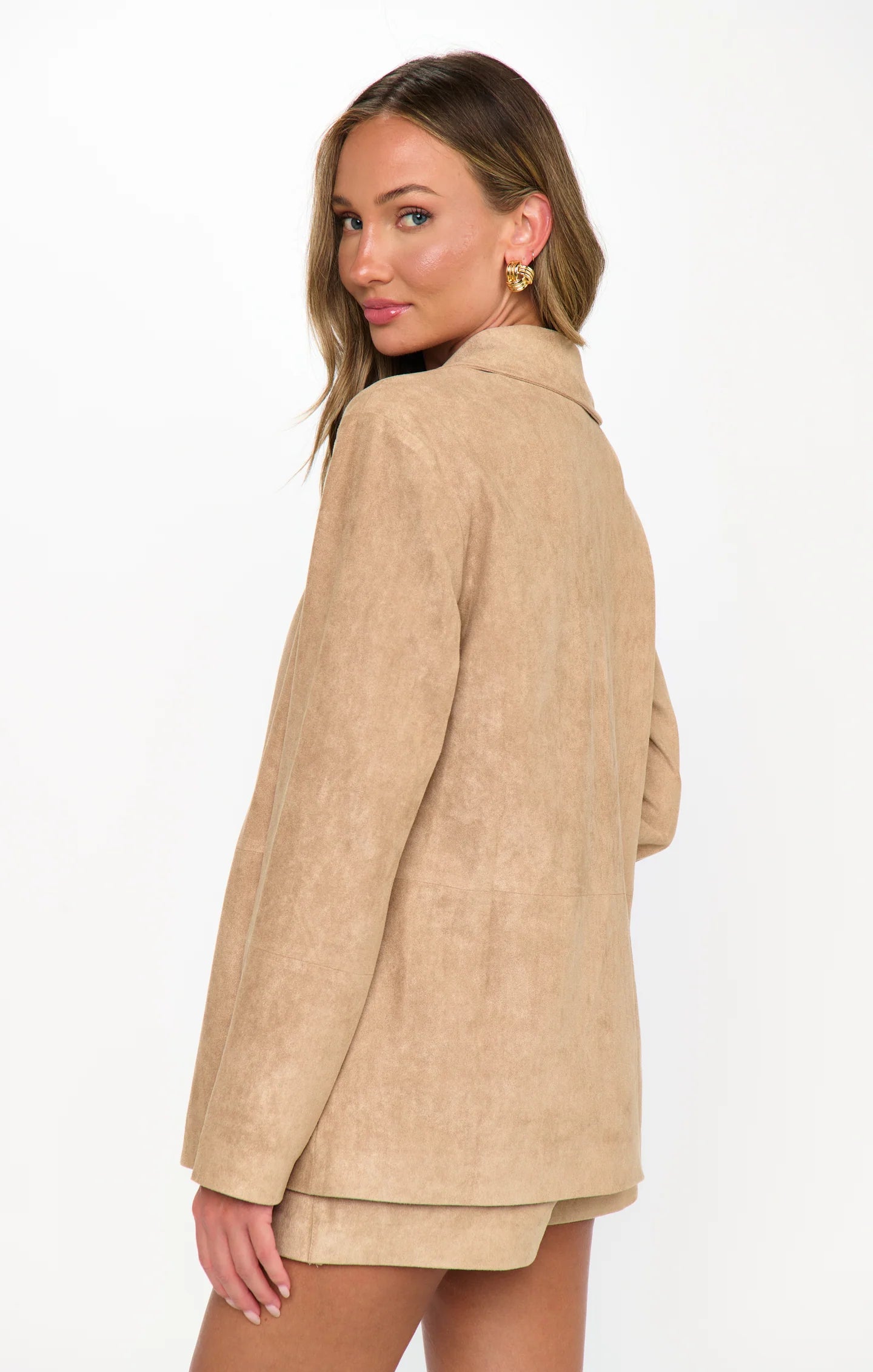 Woman wearing a beige blazer on a white background