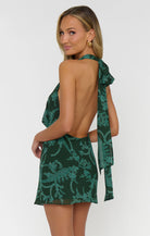 Woman wearing a green floral dress on a white background