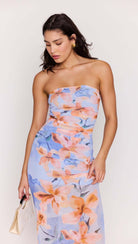 Woman wearing a strapless floral dress with a plain background