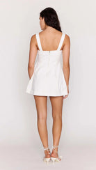Woman wearing a white dress on a plain background