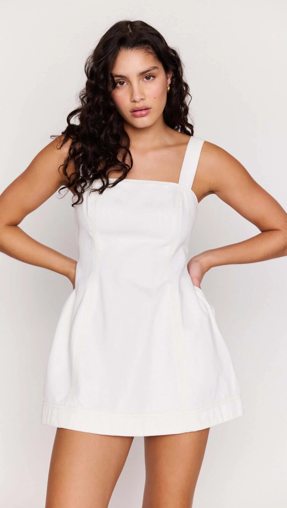Woman wearing a white dress against a plain background