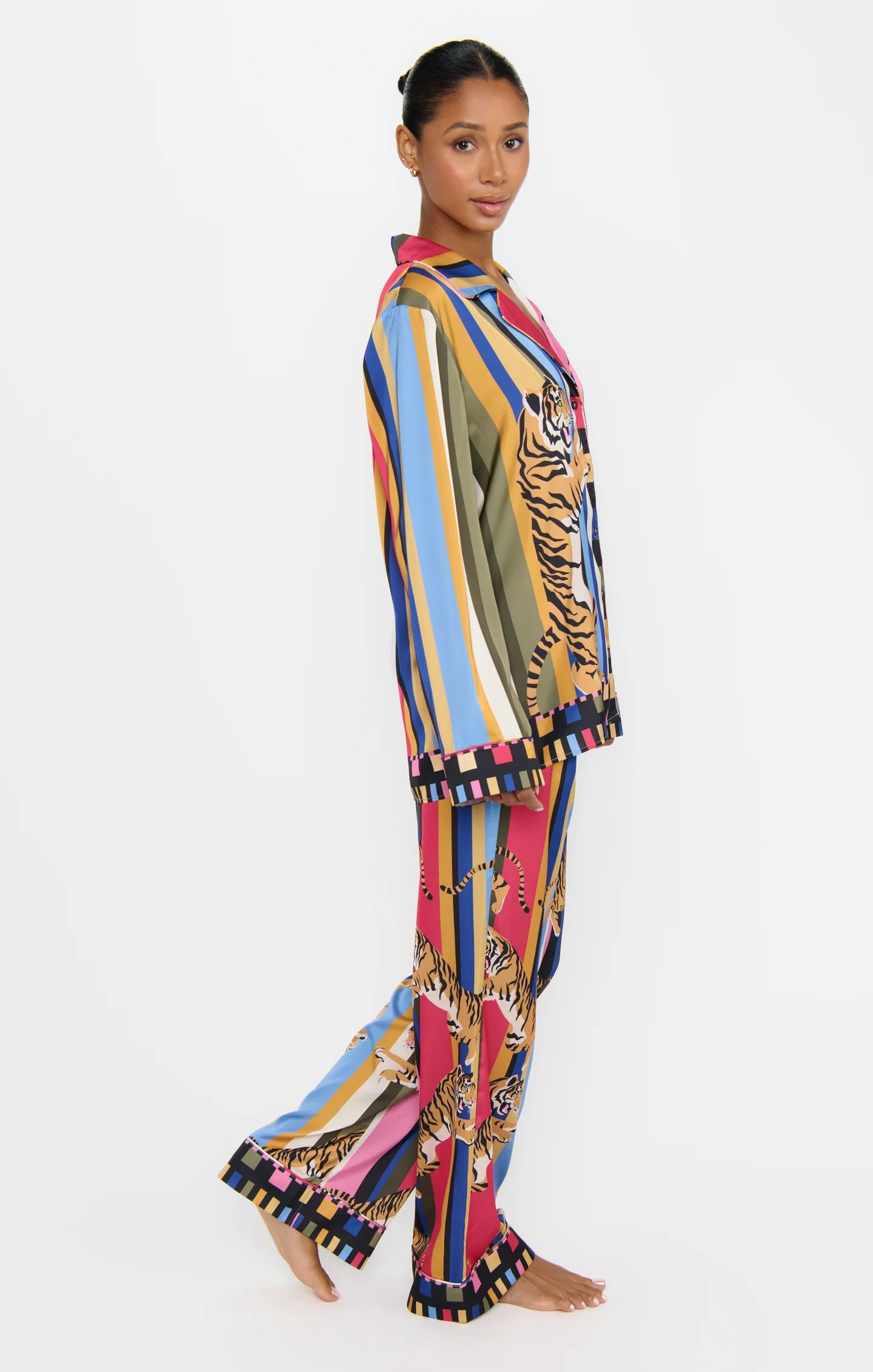Woman wearing a colorful striped outfit with tiger pattern on a white background