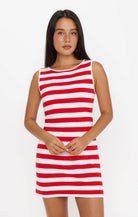 Woman wearing a red and white striped dress on a plain background