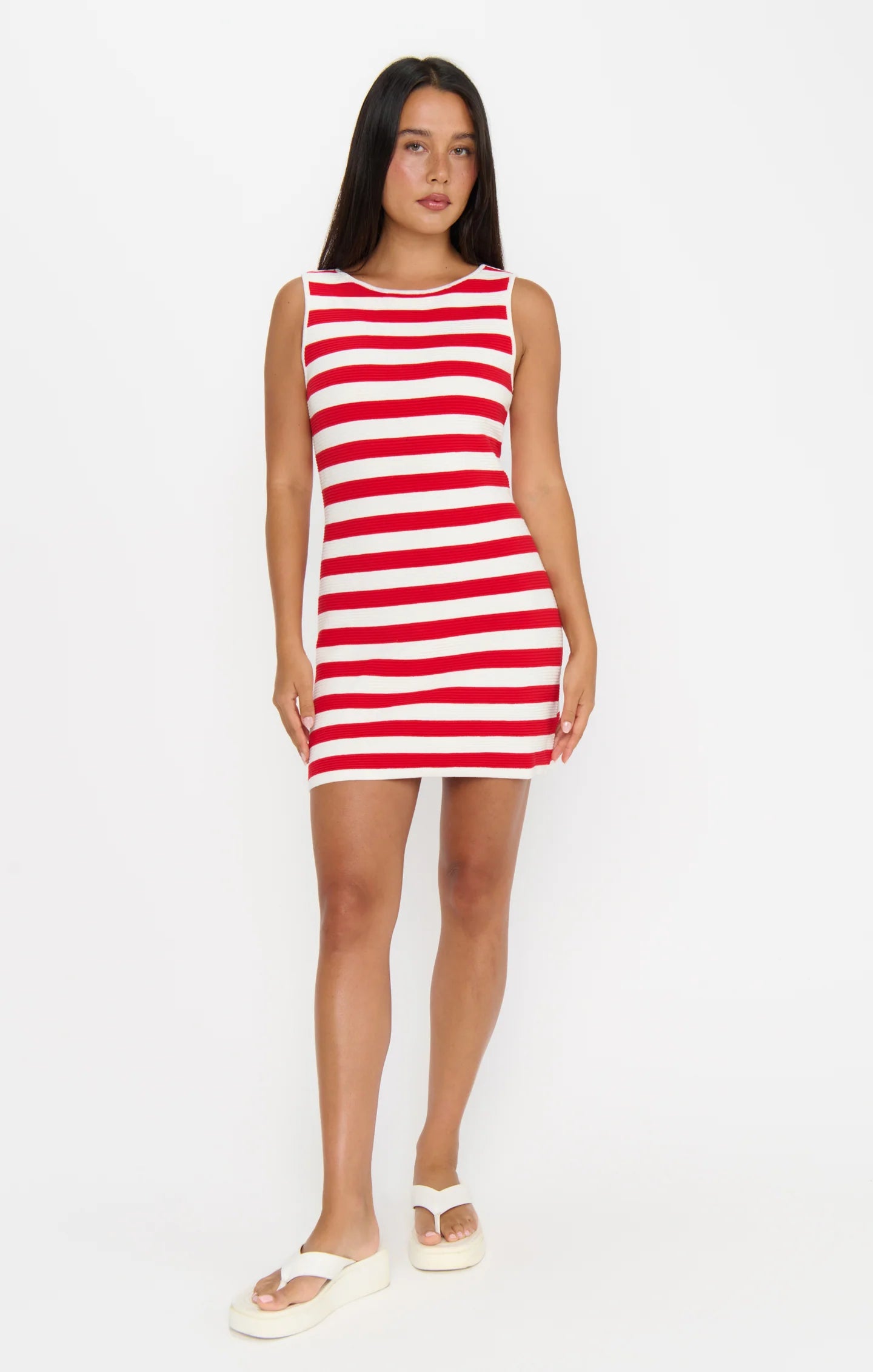 Woman wearing a red and white striped dress on a white background