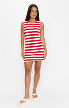 Woman wearing a red and white striped dress on a white background