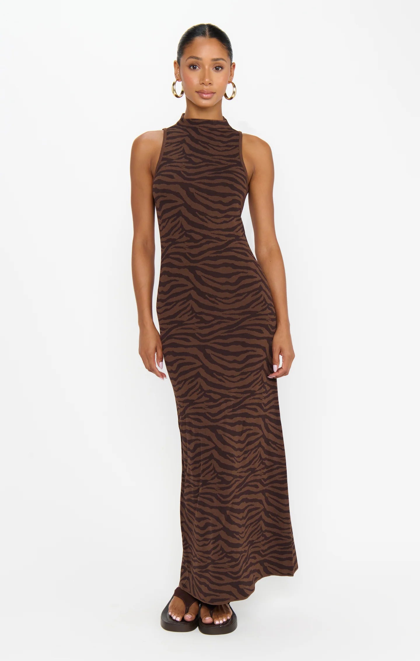 Woman wearing a brown zebra print dress on a white background