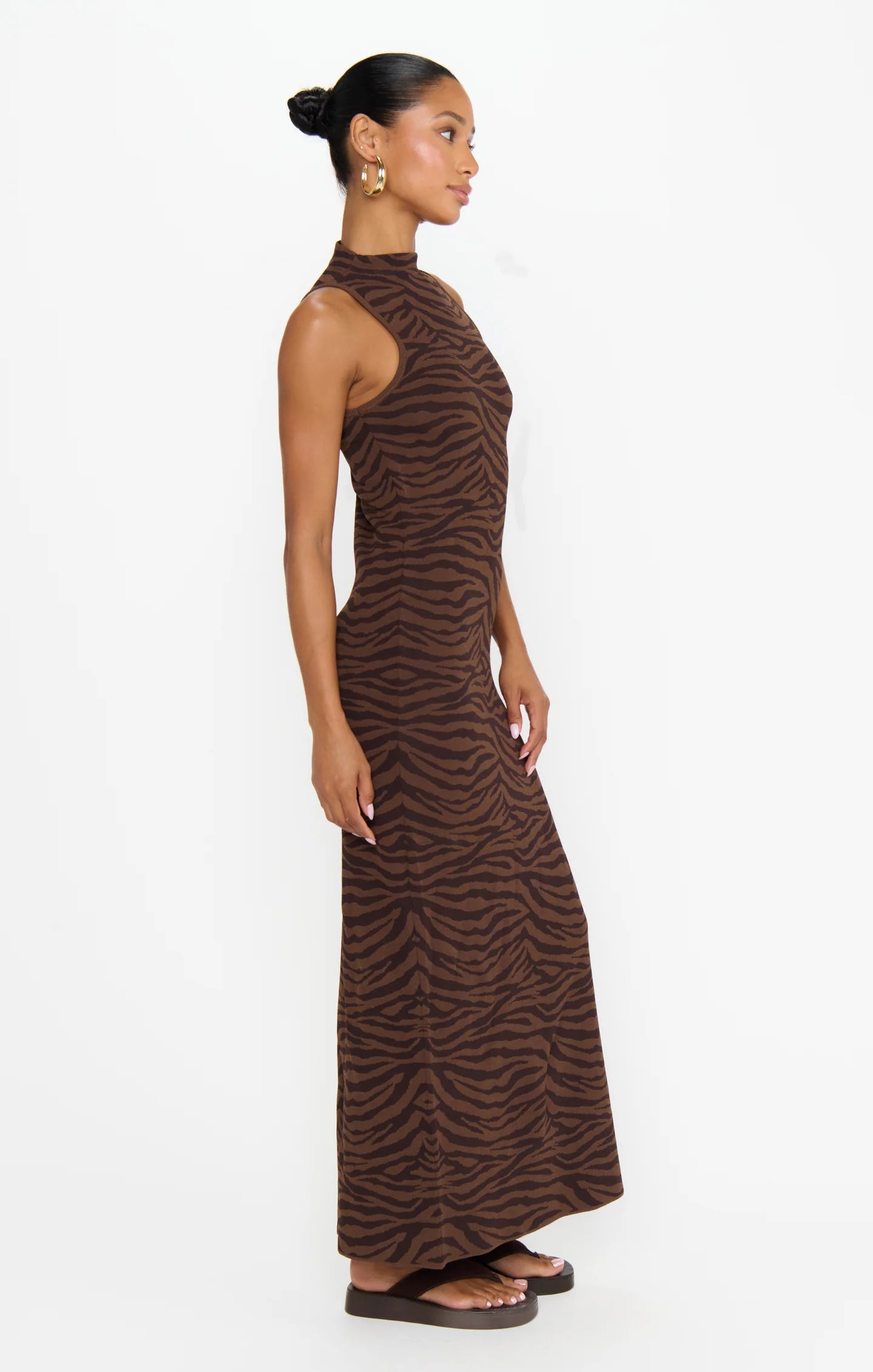 Woman wearing a brown zebra print dress on a white background