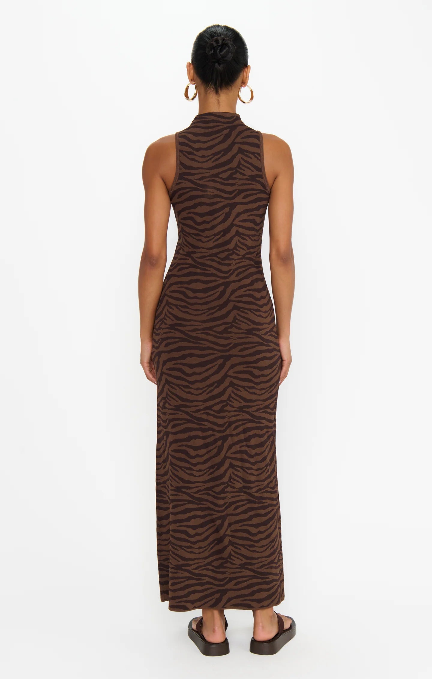 Woman wearing a brown zebra print dress on a white background