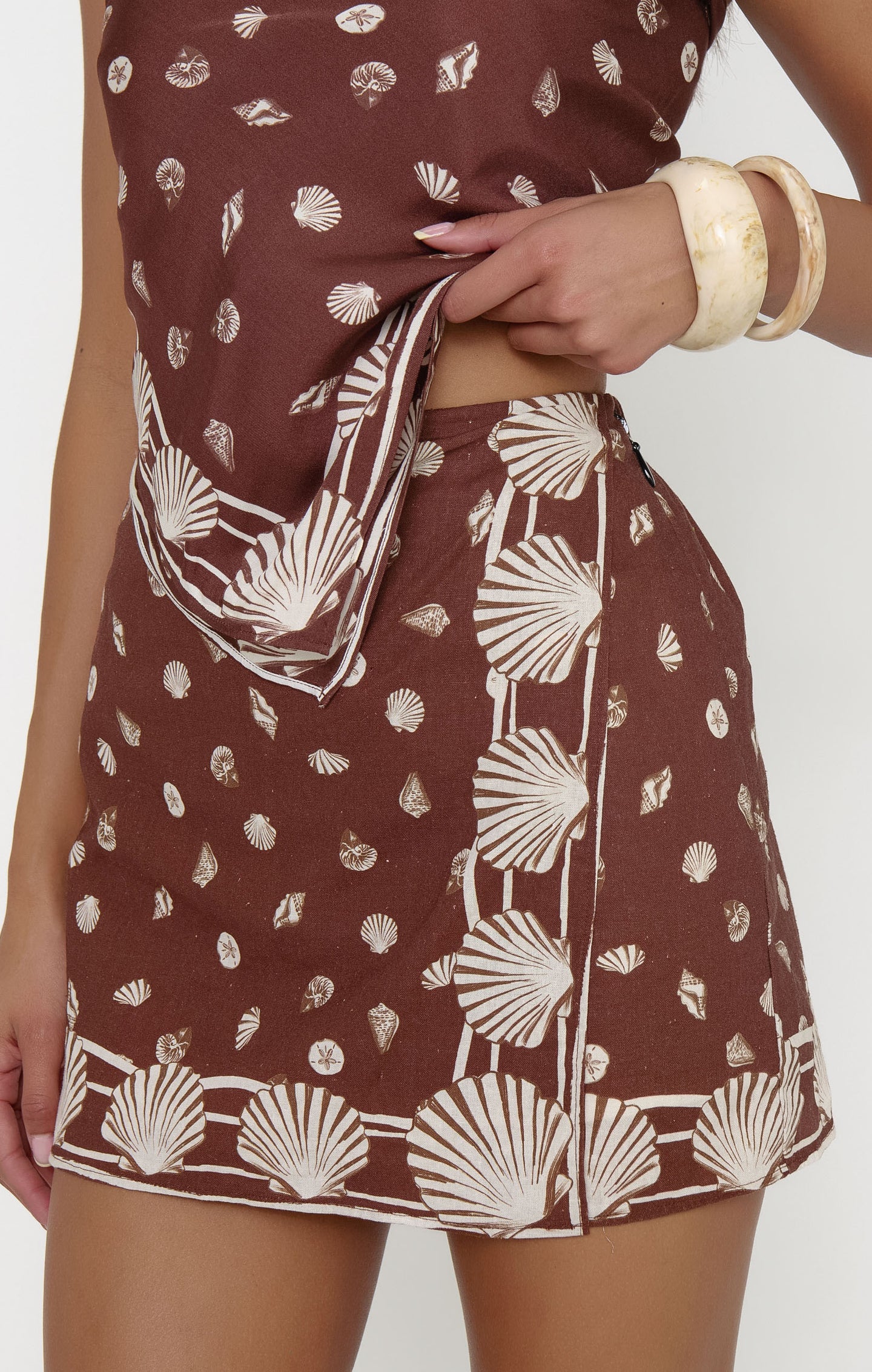 Brown dress with white shell pattern worn by a person