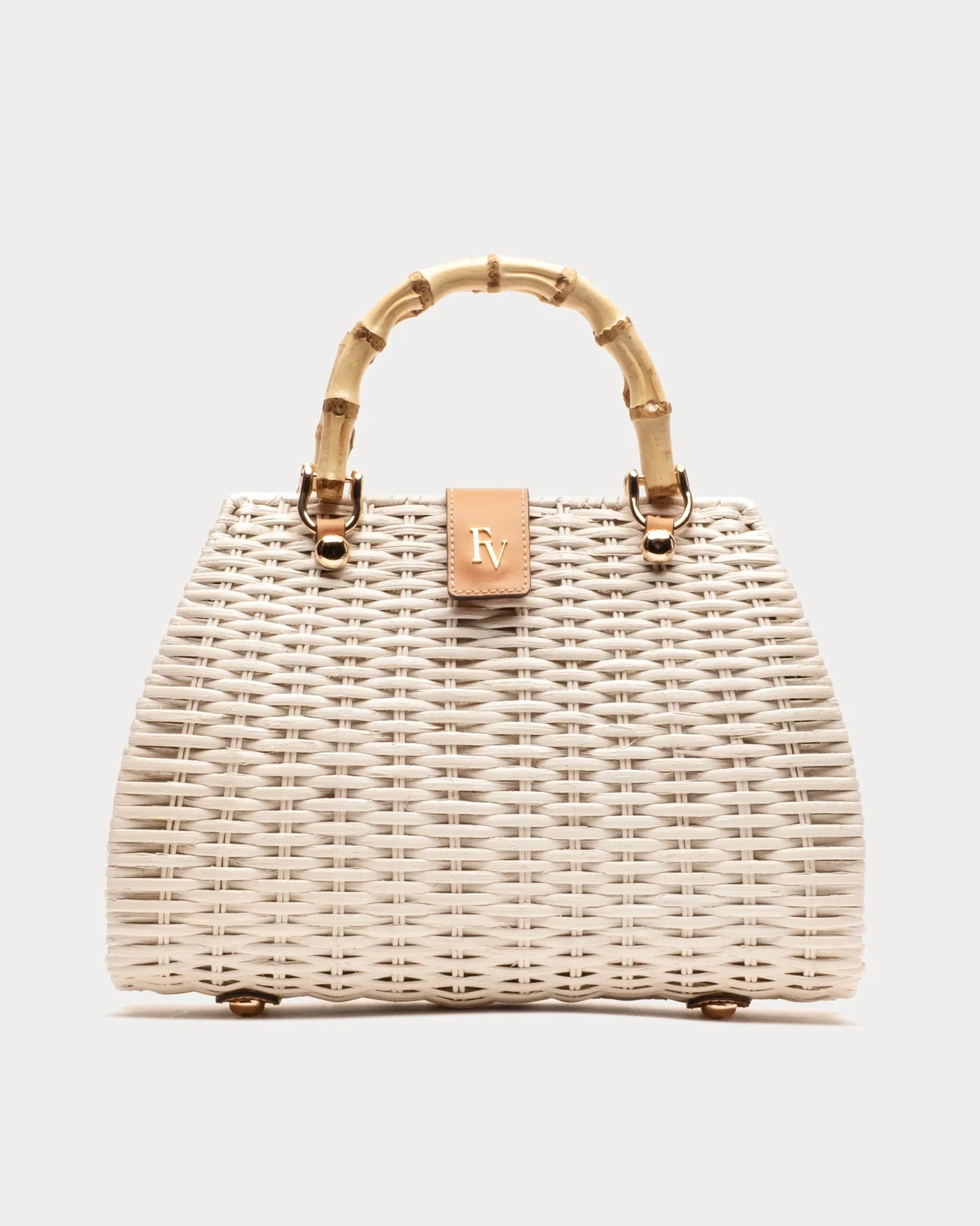 Wicker handbag with gold handle and clasp on a light gray background