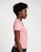 Woman wearing a pink and white striped shirt against a plain background