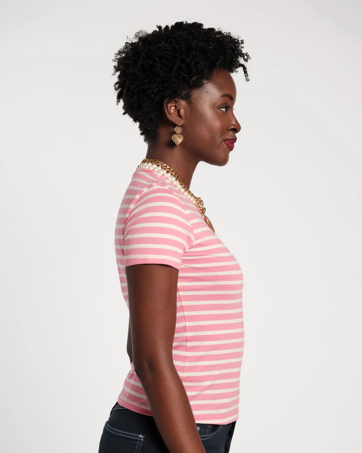 Woman wearing a pink and white striped shirt against a plain background