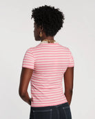 Person wearing a pink and white striped shirt on a plain background