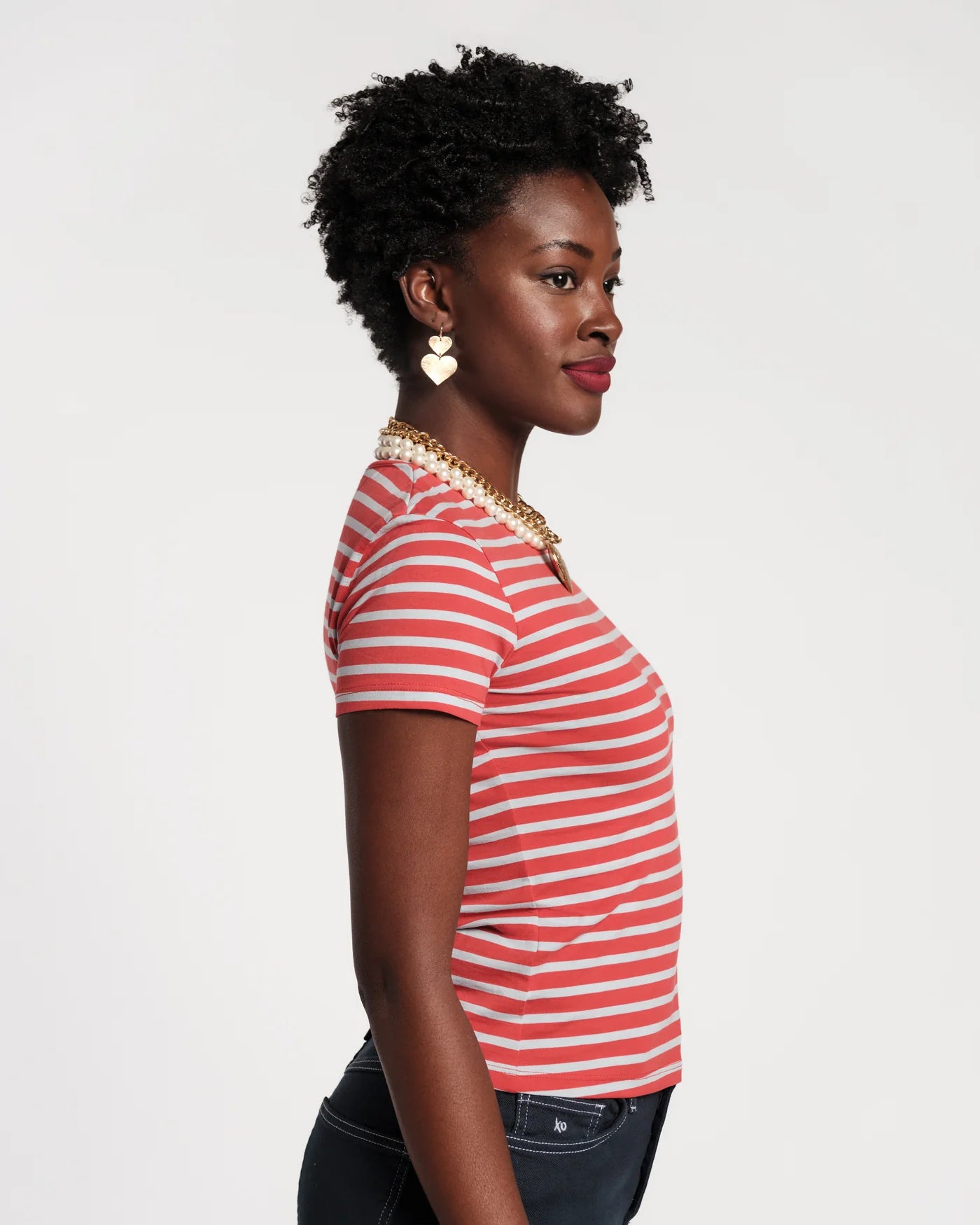 Woman wearing a red and baby blue striped shirt against a plain background