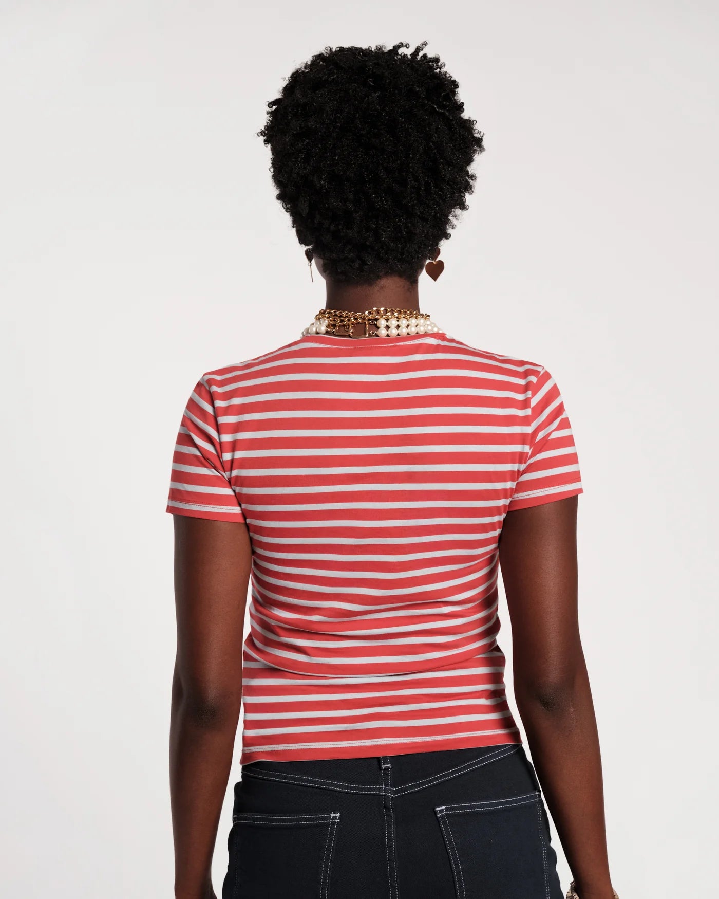 Person wearing a red and blue striped shirt on a plain background