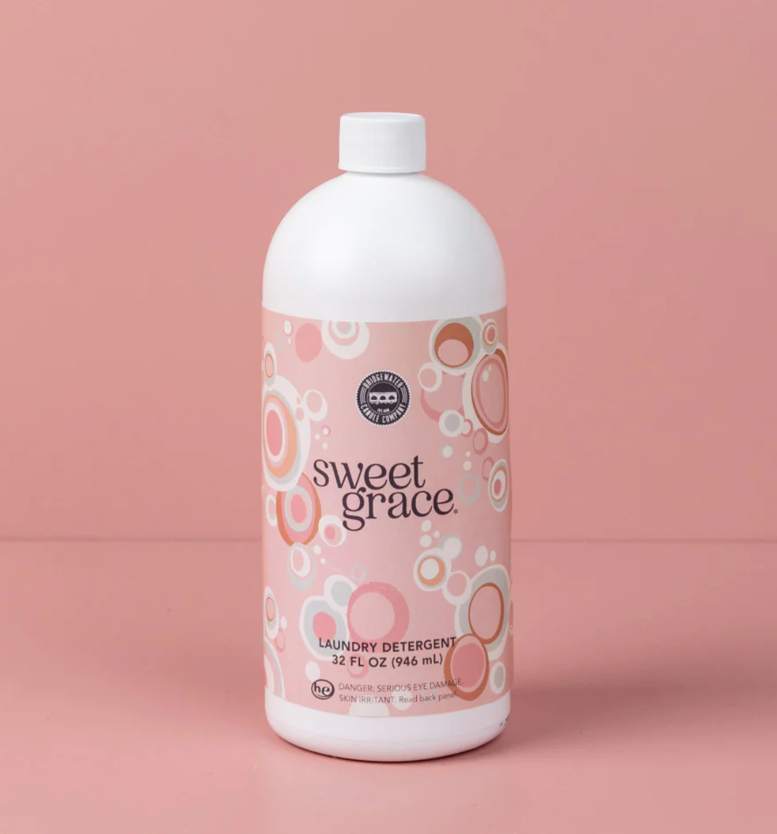 Bottle of Sweet Grace laundry detergent on a pink background