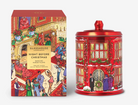 A red glass jar with a matching lid and a matching illustrated box, both featuring a festive Christmas city street scene with people and holiday decorations. The box reads 'GLASSHOUSE FANTASY Night Before Christmas Dancing Sugar Floss.