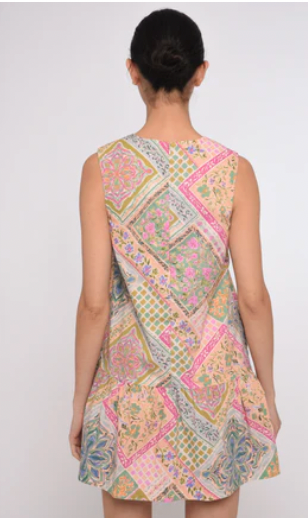 A sleeveless shift dress with a colorful patchwork paisley print, shown from the back on a model against a light gray background.