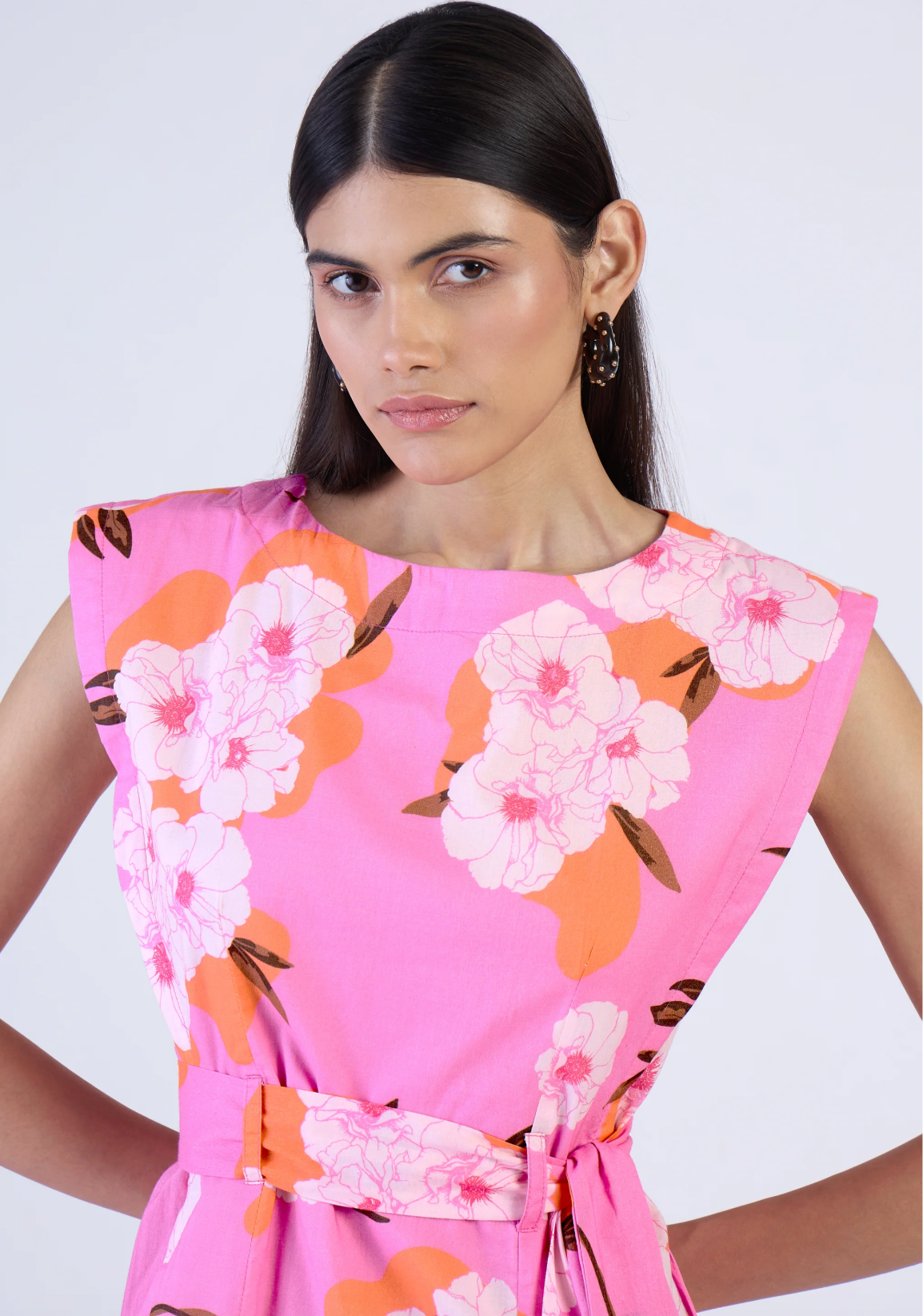 Woman wearing a pink floral dress against a white background