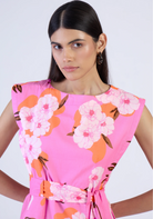 Woman wearing a pink floral dress against a white background