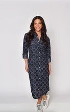 Woman wearing a dark blue patterned dress on a white background