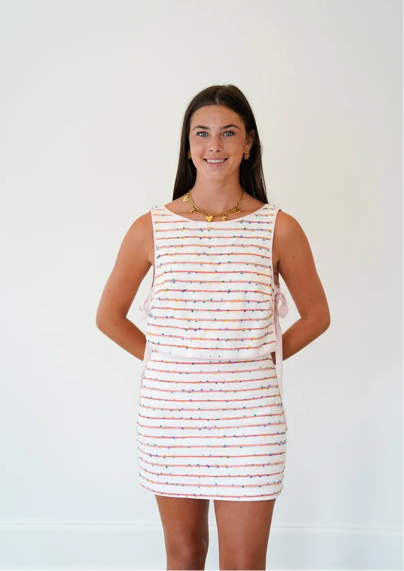 Woman wearing a sleeveless striped dress against a white background