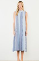 Woman wearing a blue and white striped dress on a white background