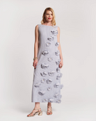 Woman wearing a light gray dress with floral patterns on a white background