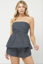 Woman wearing a strapless top and shorts set on a white background