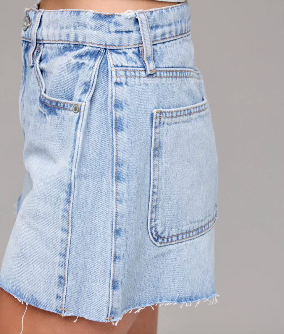 Light blue denim skirt on a gray background