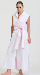 Woman wearing a white sleeveless dress with pink trim on a white background