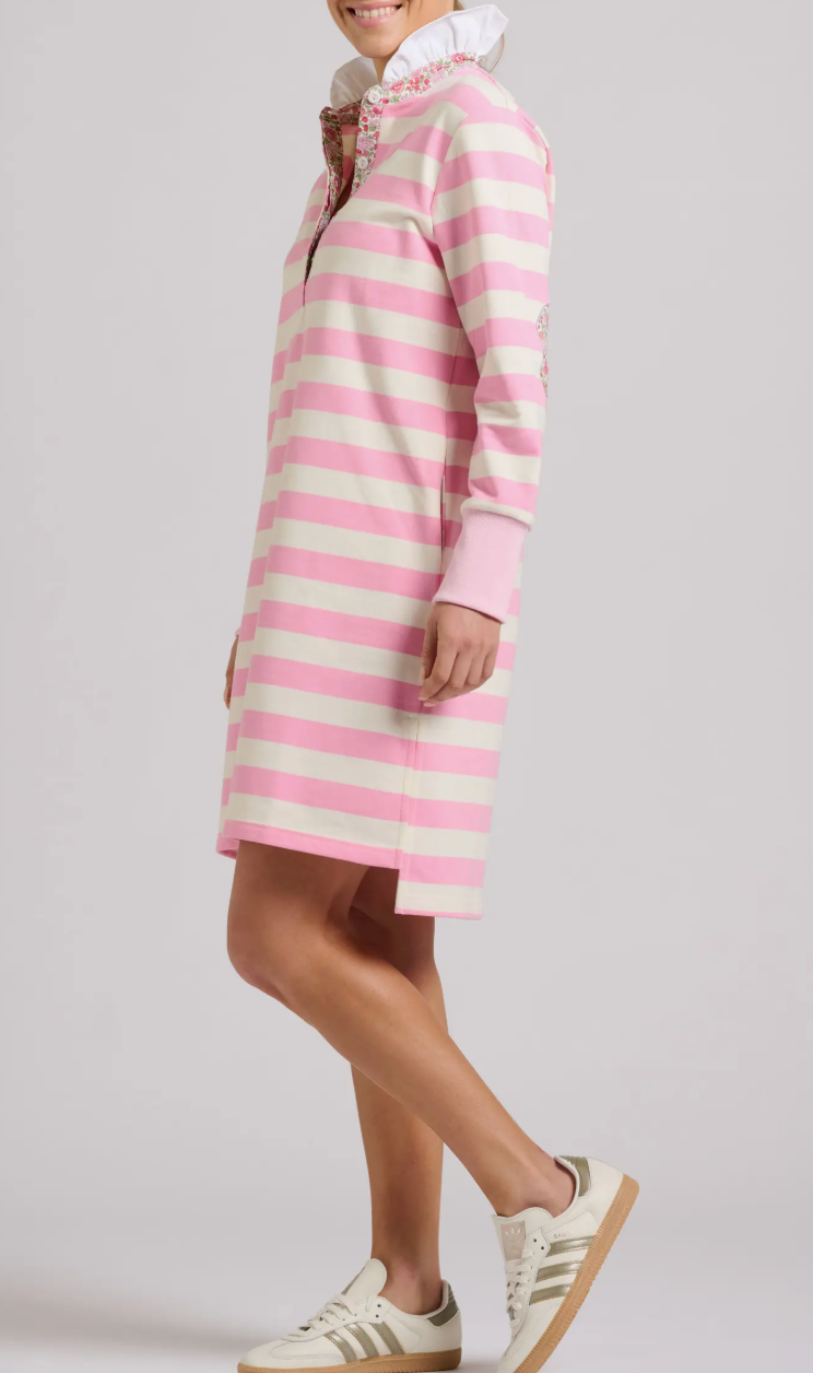 Person wearing a pink and white striped dress with a plain background