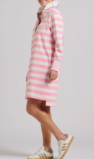 Person wearing a pink and white striped dress with a plain background