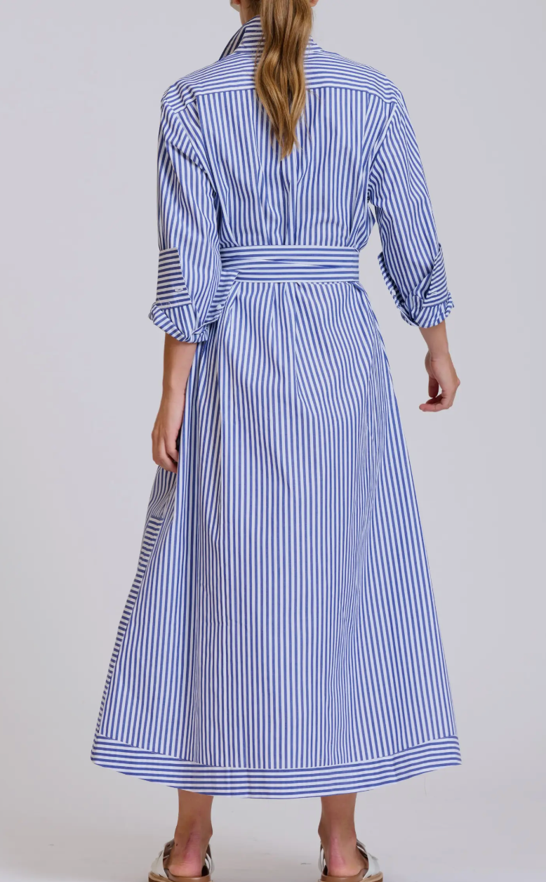 Woman wearing a blue and white striped dress on a plain background