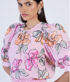 Woman wearing a pink floral blouse against a white background