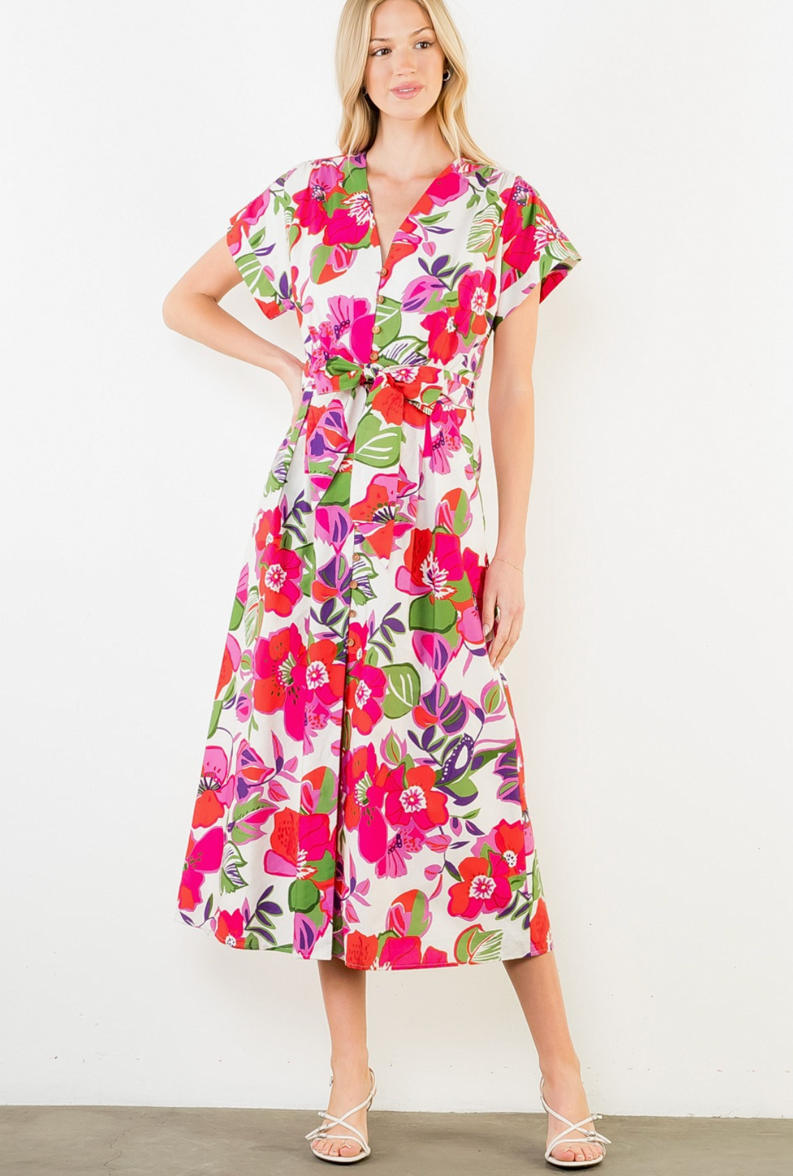 Woman wearing a colorful floral dress against a white background