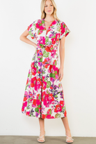 Woman wearing a colorful floral dress against a white background