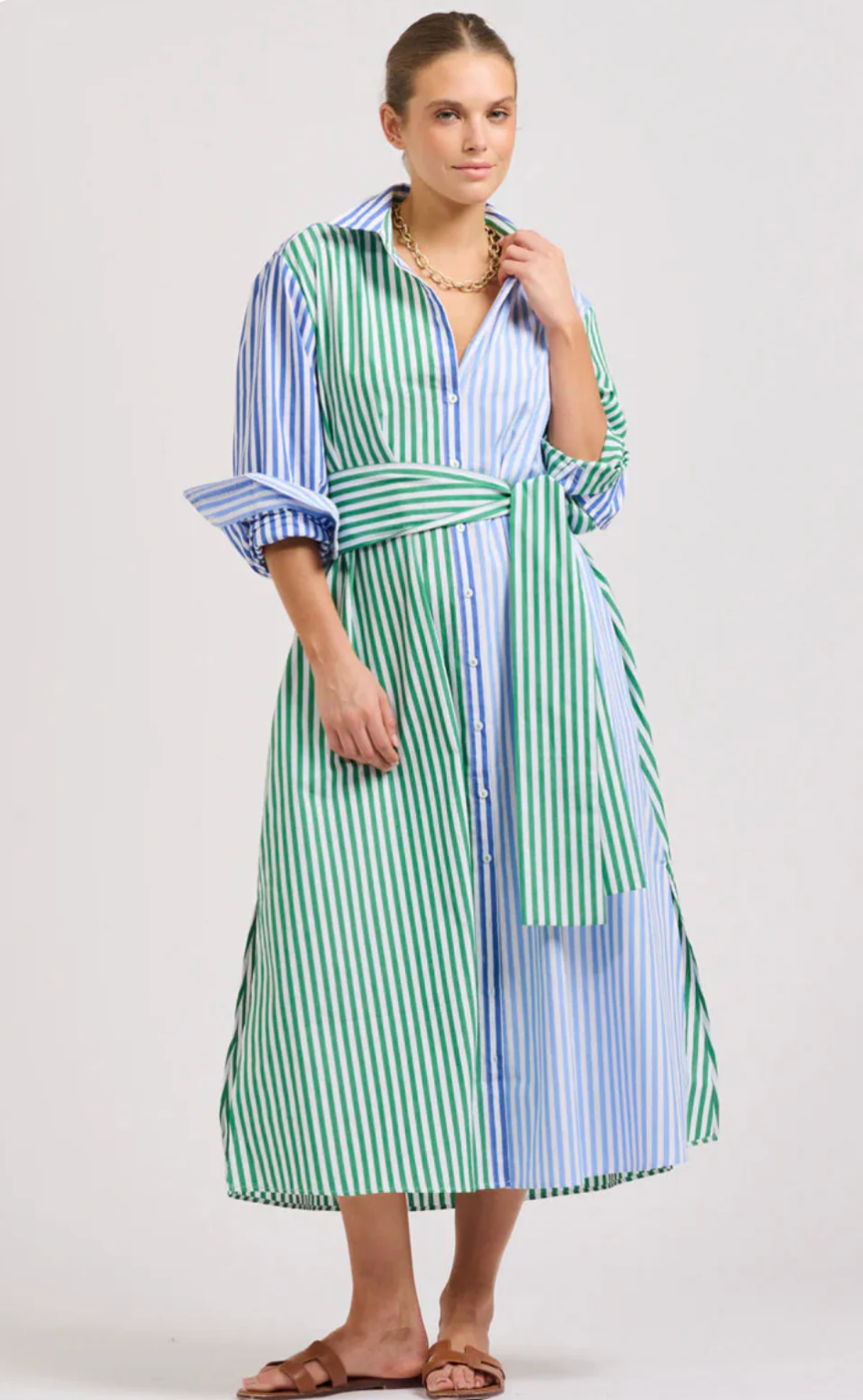 Woman wearing a green and blue striped dress on a white background