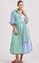 Woman wearing a green and blue striped dress on a white background