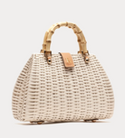 White woven handbag with bamboo handle on a light gray background