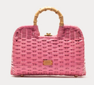 Pink woven handbag with bamboo handle on a light gray background