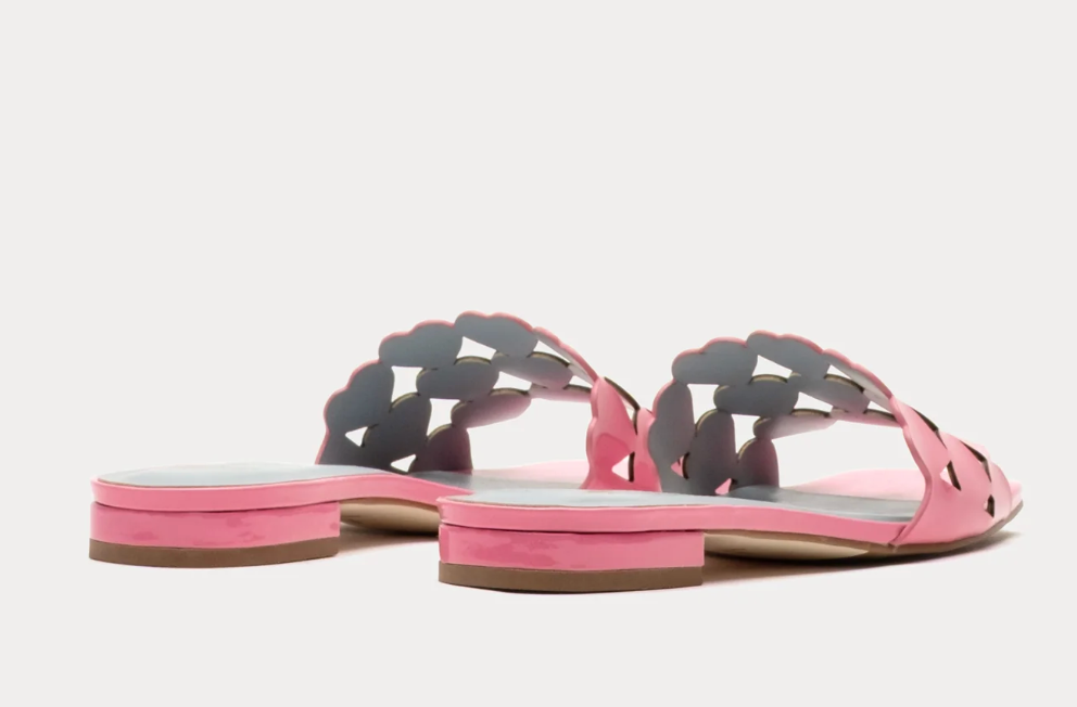 Pink sandals with cut-out design on a white background