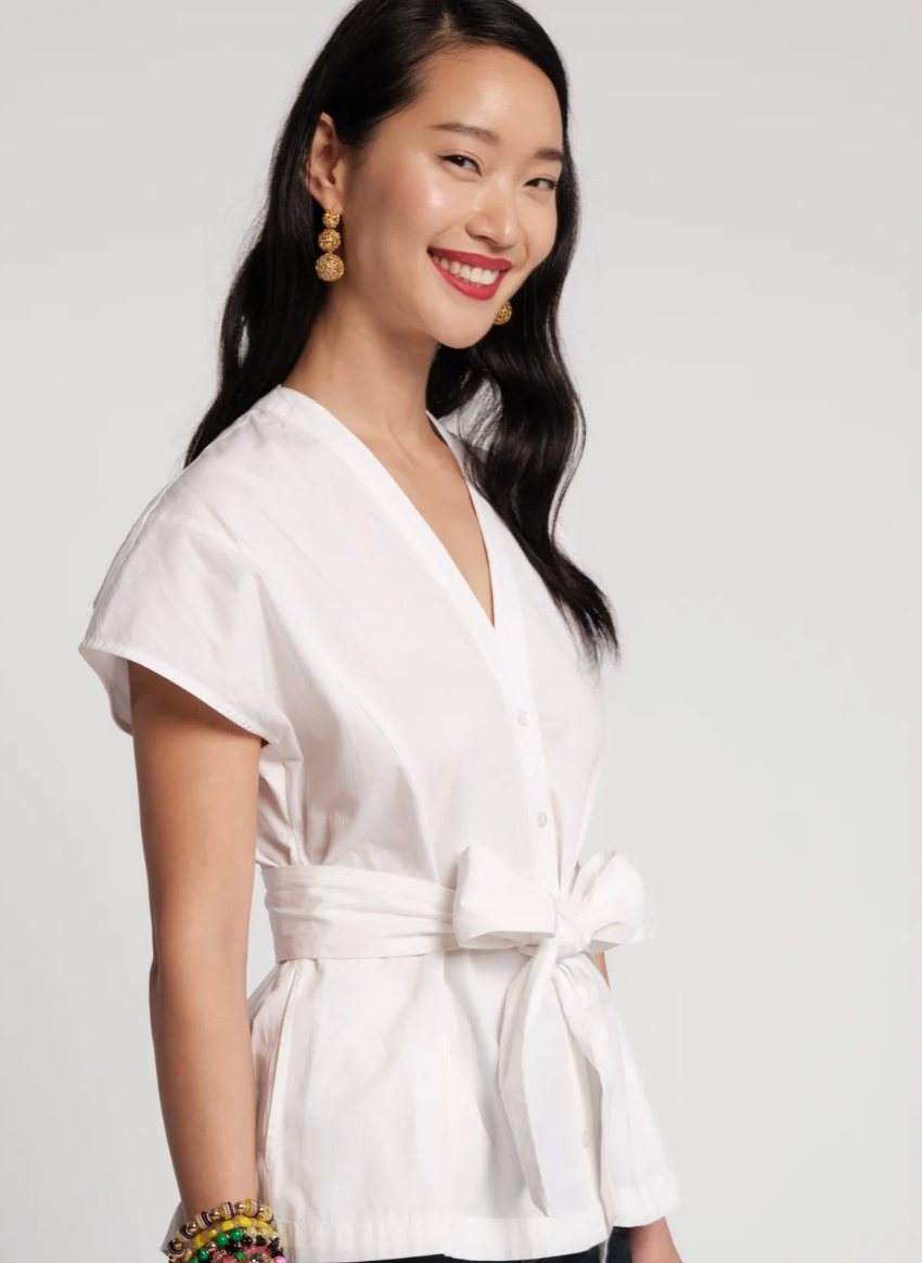 Woman wearing a white blouse with a plain background